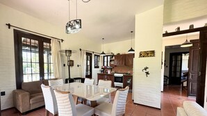A spacious living area with a dining table, chairs, a sofa, and a kitchen in the background. - Amazing Home in Bella!!!Beautiful views, peace, and everything you need to enjoy (Bella Vista)