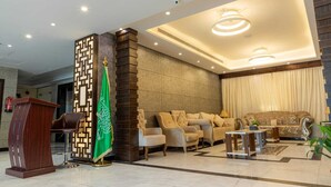 Eine moderne Lobby mit einer Rezeption, einer Sitzecke und einer Flagge.