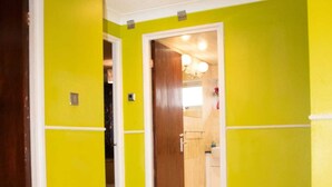 A hallway with bright yellow walls and wooden flooring.
