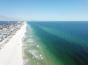 An aerial view of a coastal area with a long stretch of beach and a cityscape in the background. - 5-Min Walk to Beach, Private Pool, Dog-Friendly! (Gulf Shores)