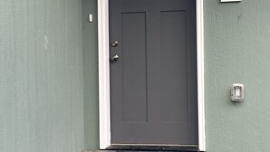 A dark grey door with a white frame and a small window above it. A white number '4091' is displayed on the wall to the right of the door. - 'Mother-In-Law' apartment in rural neighborhood.King bed, Kitchenette, fullbath. (Wasilla)