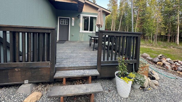 A house with a wooden deck, a door, and a number sign '4091'. - 'Mother-In-Law' apartment in rural neighborhood.King bed, Kitchenette, fullbath. (Wasilla)