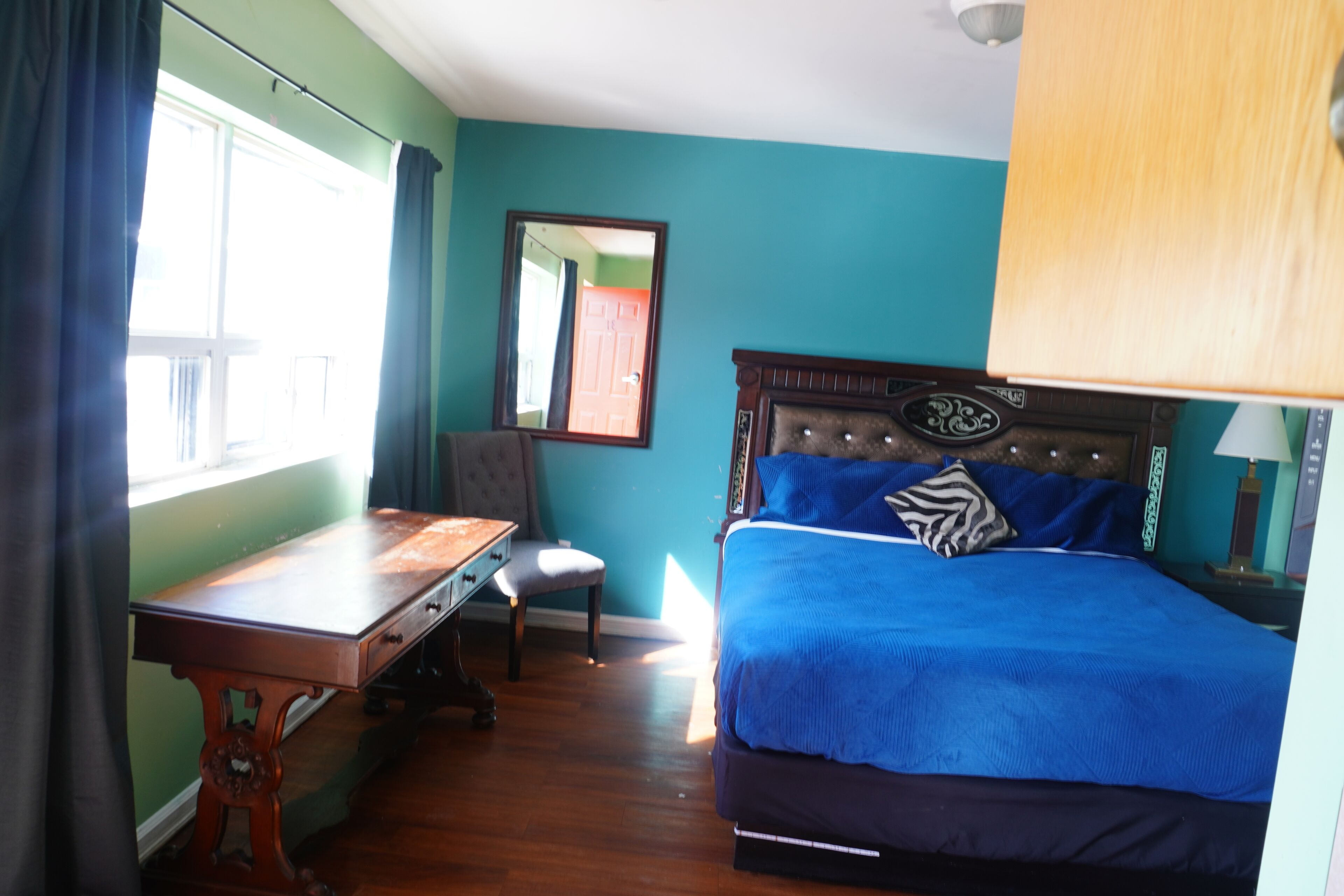 A room with a bed, a desk, and a chair.
