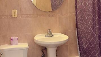 A bathroom with a toilet, sink, and bathtub.