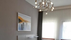Une chambre moderne avec un grand lit, une chaise, un bureau et un lustre original.