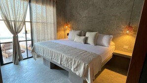 Ein Schlafzimmer mit einem großen Bett, einem Deckenventilator und zwei Wandlampen.