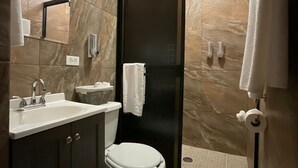 Een moderne badkamer met toilet, wastafel en douche.