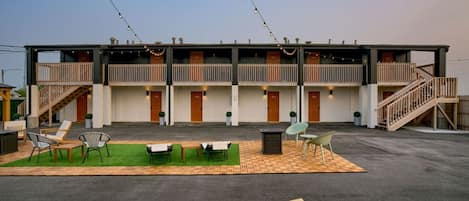 Un bâtiment à deux étages doté de balcons, d’une terrasse et d’un toit plat.