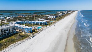 Un hôtel en bord de mer composé de plusieurs bâtiments, doté d’une plage et offrant une vue dégagée sur l’océan.
