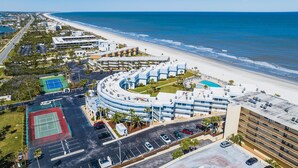 Un hôtel situé sur la côte, offrant une vue sur la plage, doté d’un court de tennis et d’un espace piscine.