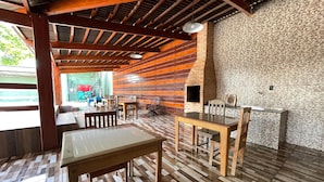 A rustic interior with wooden beams, a brick oven, and a tiled floor. - Hotel Villa Green  (Tome-Acu)