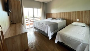 A hotel room with two beds, a TV mounted on the wall, and a sliding glass door leading to an outdoor area. - Hotel Villa Green  (Tome-Acu)