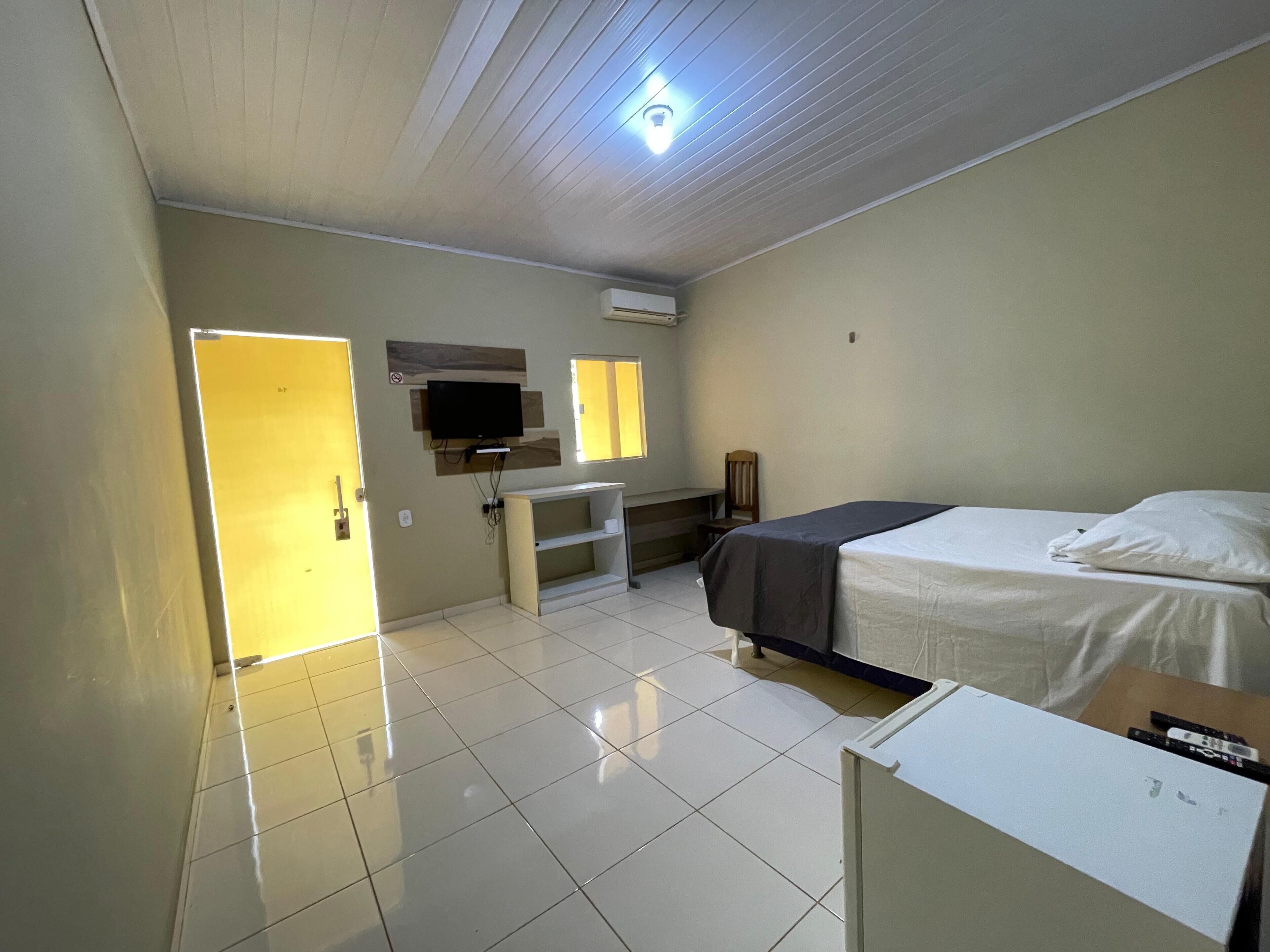 Une chambre d’hôtel avec un lit, un bureau, une télévision et une fenêtre.
