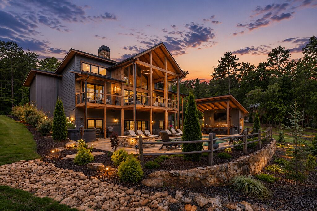 A large, multi-level wooden house with a balcony, outdoor seating area, and a stone retaining wall.