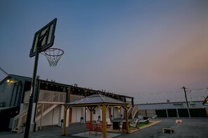 A basketball court with a hoop, a covered seating area, and string lights. - 5 min. to Lincoln's top attractions. King-size bed, kitchenette & outdoor space (Lincoln)