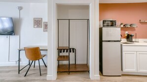 Une cuisine moderne avec des meubles blancs, un réfrigérateur blanc, un four à micro-ondes et une machine à café.