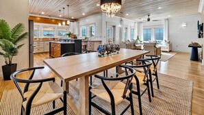 A spacious kitchen with wooden cabinets, a central island, and pendant lighting.