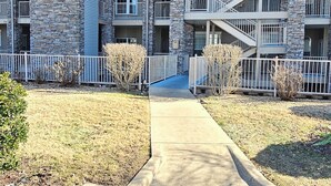 A multi-story hotel with stone facade, balconies, and a central staircase. - Paradise Quarters Walk-in Suite at the Legacy at Thousand Hills! Great Rates! (Branson)