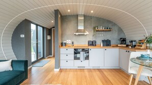 Una cocina moderna con armarios blancos, encimera de madera y estufa integrada.