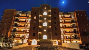 A multi-story hotel with balconies, a central courtyard, and a nighttime view. - Private Jacuzzi w/  Ocean Views, Copala Quivira - 20% off F & B - 3 Bed (Cabo San Lucas)
