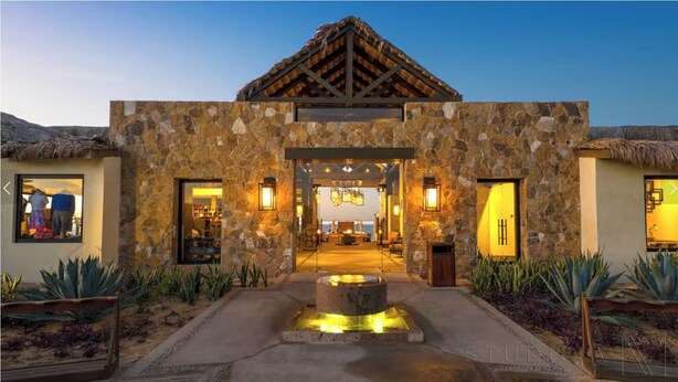 A stone building with a thatched roof entrance, a central courtyard with a water feature, and a view of the sea. - Private Jacuzzi w/  Ocean Views, Copala Quivira - 20% off F & B - 3 Bed (Cabo San Lucas)