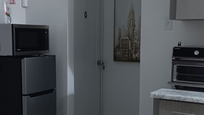 A kitchen with a refrigerator, microwave, and cabinets.
