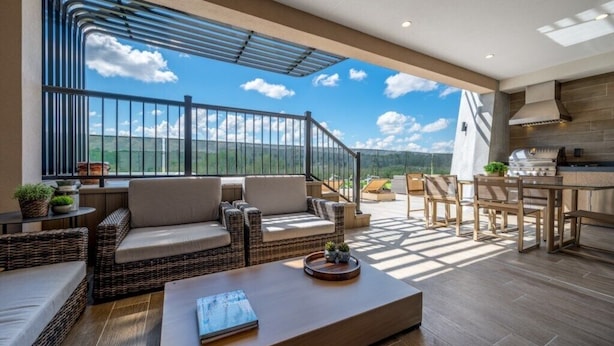 Un ampio balcone con mobili in vimini, un'area pranzo e una cucina.