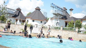 A swimming pool area with multiple people enjoying the water. - Turaco Intercounty Resort Limited  (Kisumu)