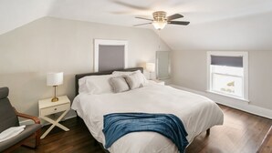 A bedroom with a bed, bedside tables, a chair, a ceiling fan, and windows. - New updated home w/ porch and Fenced yard in DT Libertyville Near Naval Base (Libertyville)