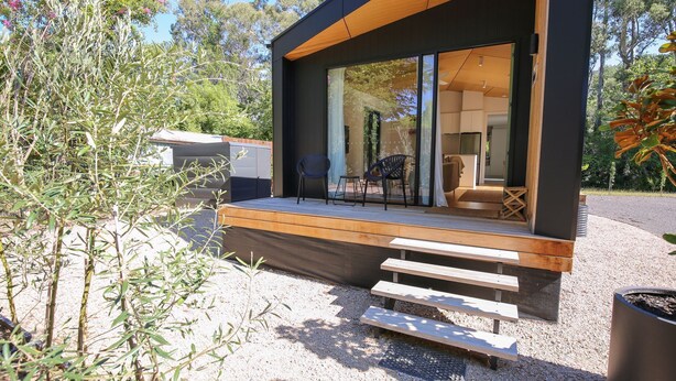 A modern outdoor seating area with a wooden deck, a bench, and two chairs. - The Rocks - Olive Retreat (Bright)