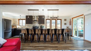 A modern kitchen with a central island, wooden ceiling, and a dining area with four chairs. - Rustic Ski Retreat! 2 min. walk to Ski Slopes, 6TVs, Linens, Wi-Fi, A/C, Firepit (bushkill)