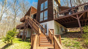 A multi-level wooden cabin with a staircase leading to a deck. - Beautiful Modern Lodge! Pool Table,8 TVs Wi-Fi, Linen provided, Central AC (Saw Creek)
