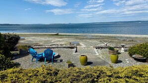 Een zitgedeelte aan het strand met stoelen en plantenbakken.