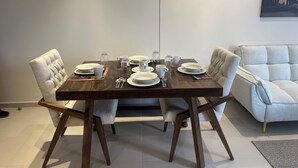 A dining area with a wooden table set for four, surrounded by upholstered chairs. - Beautiful loft in amazing Guadalajara with AC, WiFi, fitness room, and workspace (Guadalajara)