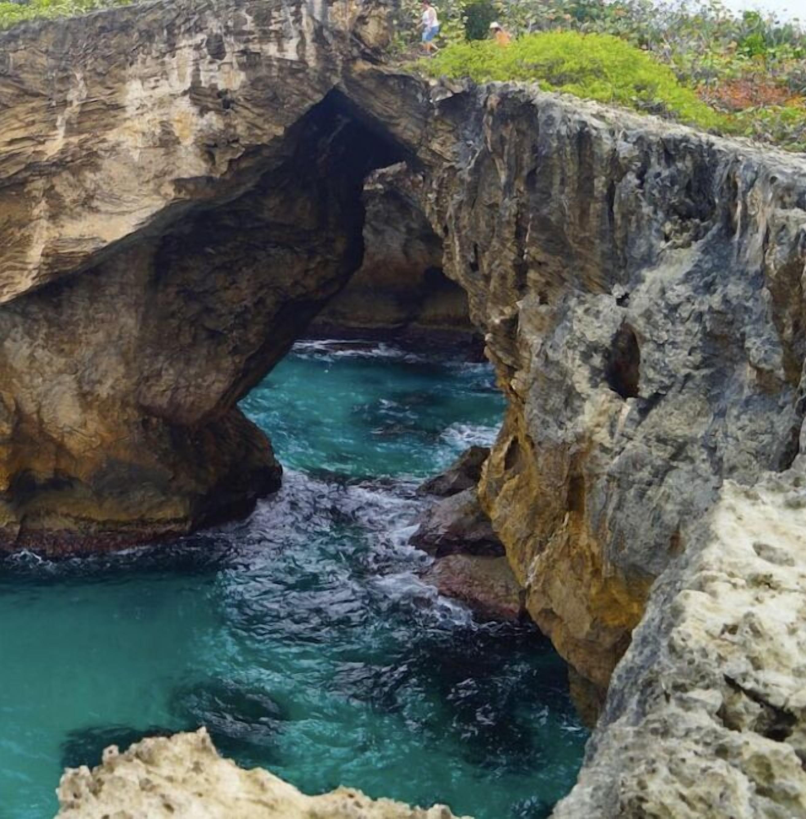 A natural rock formation with a clear water passage.