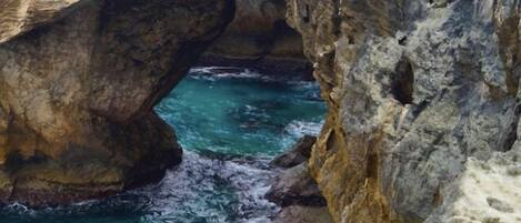 A natural rock formation with a clear water passage.
