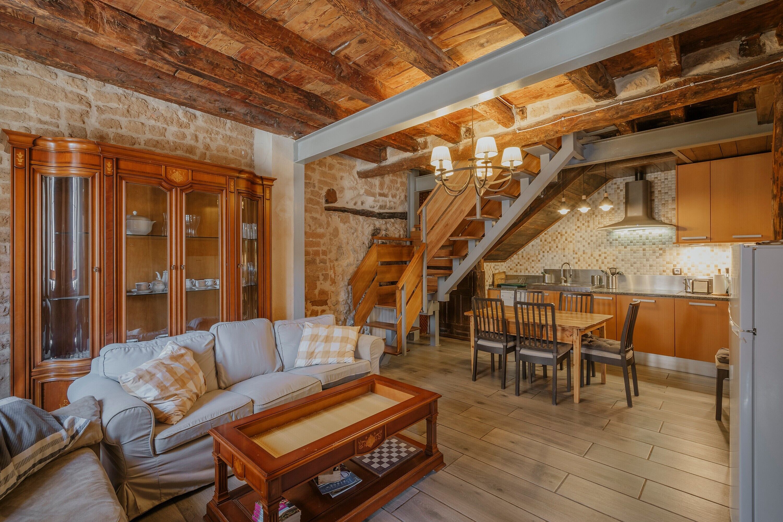 Un salon confortable avec un canapé, un meuble en bois et une table à manger avec des chaises.