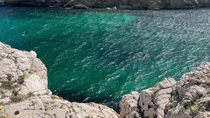 Una costa rocosa con agua turquesa cristalina y acantilados escarpados.