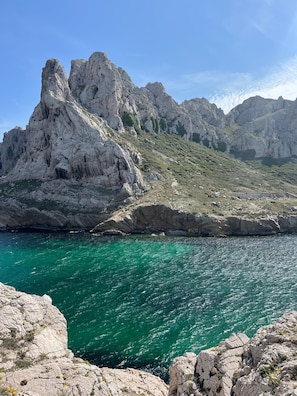 Una costa rocosa con agua turquesa cristalina y acantilados escarpados.