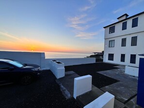 A building with a flat roof, white walls, and multiple windows.