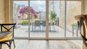 A room with a sliding glass door leading to an outdoor patio area. - Guest House 'La Chambre Bleue' with Shared Terrace, Shared Garden and Wi-Fi (Eymet)