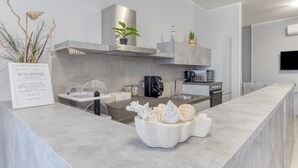 Eine moderne Küche mit Marmorarbeitsplatte, Edelstahlgeräten und dekorativen Pflanzen.