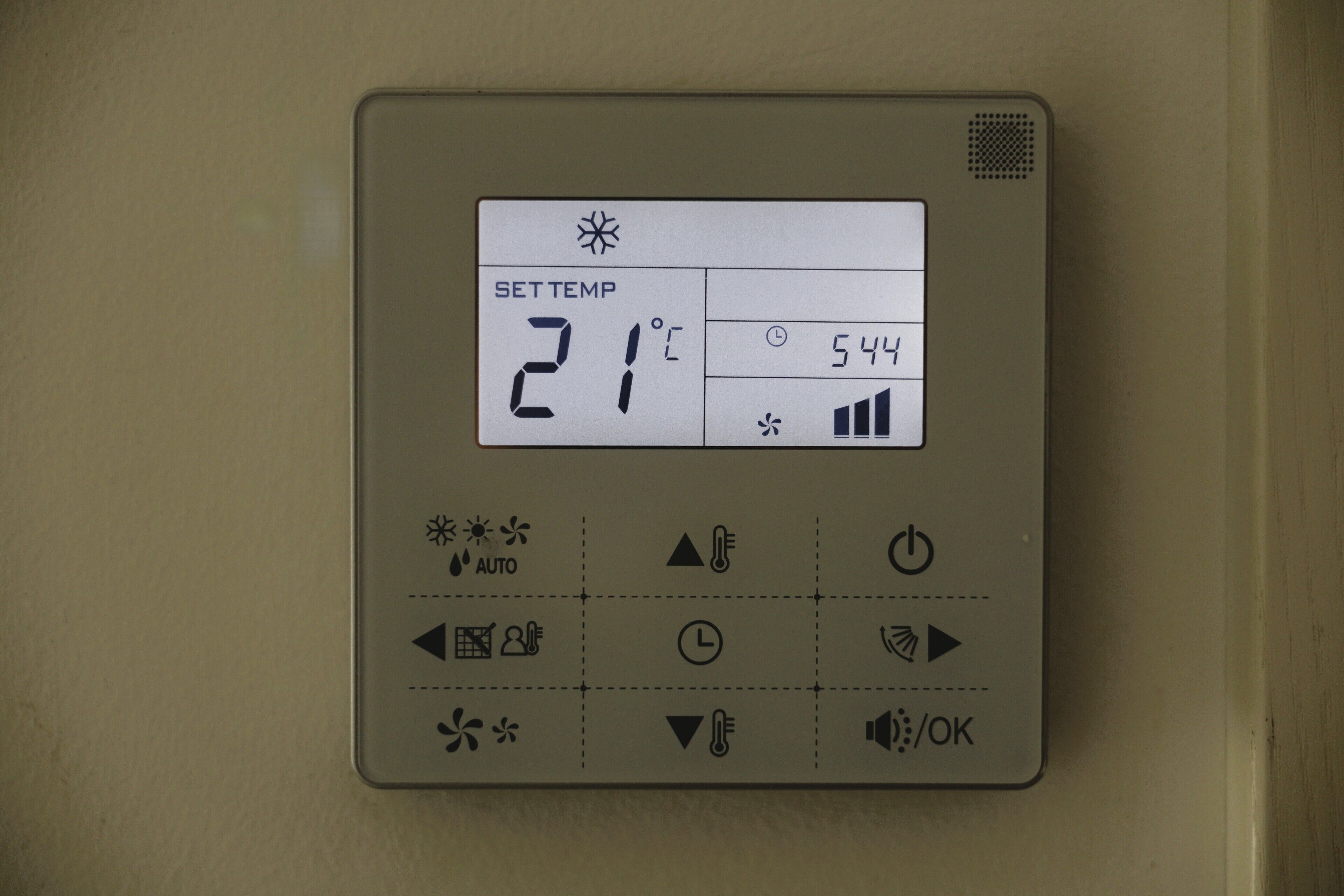 A thermostat with a digital display, buttons, and a control panel.