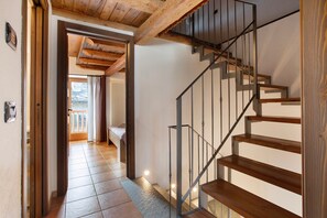 A staircase with wooden steps and metal railings, leading to an upper floor.