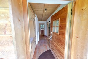 Ein Holzflur mit Schränken, einem Fenster mit floralem Dekor und einer Deckenleuchte.