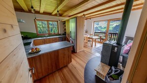 Ein Holzhaus-Interieur mit Küche, Essbereich und Kamin.