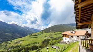 Eine Berglandschaft mit einem Holzbau und einem Balkon.