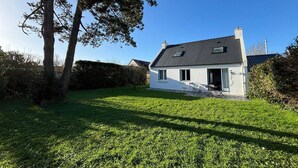 A single-story house with a sloped roof, a small porch, and a well-maintained lawn.