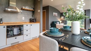 A modern kitchen with a built-in oven, a stainless steel range hood, and a wooden countertop. - Fabulous Two Bedroom Eco Pod, Old Chalford Estate (Chipping Norton)