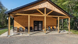 A wooden cabin with a covered porch, outdoor seating, and a door. - Tiny Home · Hot Tub · Fire Pit · Romantic Escape (Laurelville)